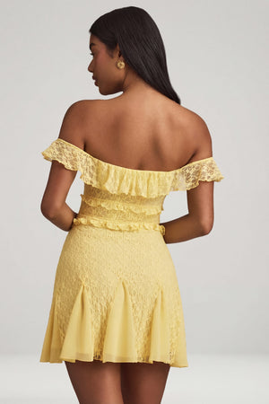Oh Polly's Yarelis wearing the Nahida Mini Dress in Pastel Yellow Stretch Lace fabric perfect for summer garden parties