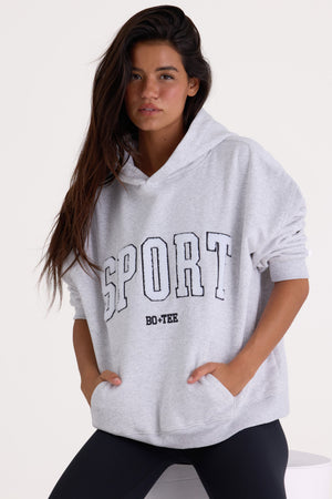 Bo+Tee model Kiele wearing the Varsity Hoodie in Marl Grey Cotton fabric perfect for travel days